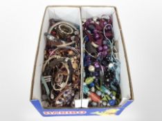A two-division box containing assorted costume jewellery, bead necklaces, bangles, etc.