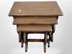 A reproduction oak nest of three tables,