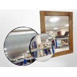 A contemporary wood-framed mirror and two circular mirrors.