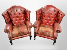 A pair of Chesterfield red button leather wingback armchairs on carved ebonised feet