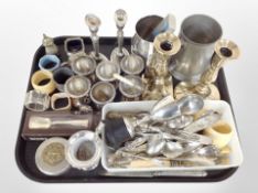 A group of silver-plated egg cups, pair of candlesticks, tankard, assorted cutlery, napkin rings.