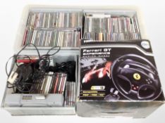 A box containing Sony Playstation 1 console, Ferrari GT racing wheel in box, assorted CDs.