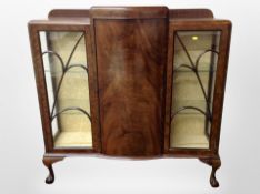 A 1920s mahogany bow front display cabinet on claw and ball feet, width 122cm.