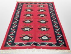 A flat weave Kilim rug on red ground,