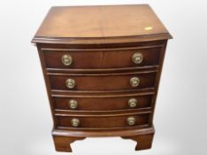 A reproduction mahogany four drawer bow-front miniature chest,