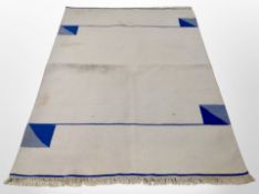 A flat weave rug on cream ground,