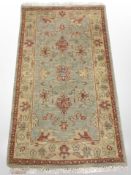 A machine made Persian design rug on green ground,