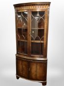 A good quality reproduction mahogany bow-front corner cabinet,