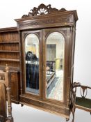 A 19th century French carved oak mirrored double door wardrobe,