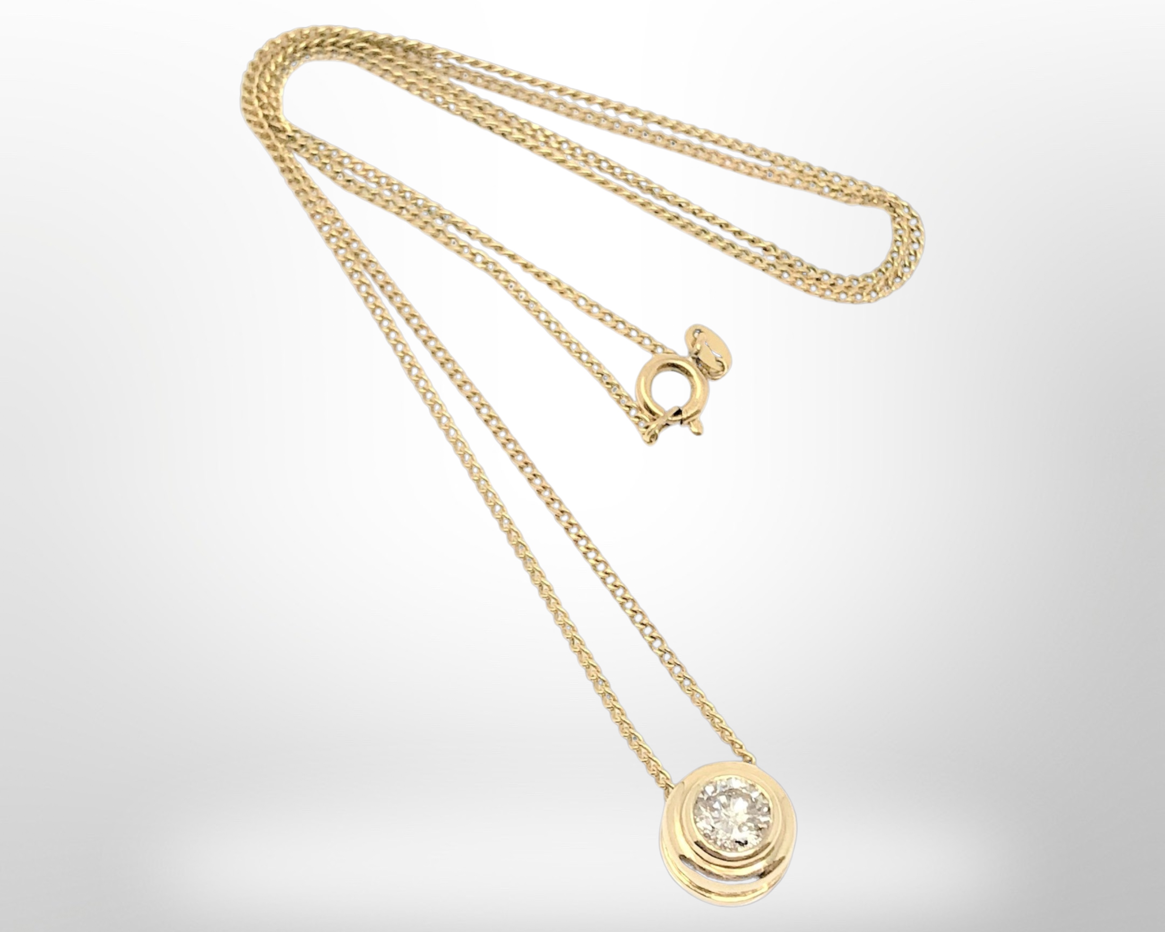 A solitaire diamond pendant, the brilliant cut stone set in 18ct gold weighing approximately 0.