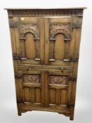 A reproduction carved oak linen cabinet,