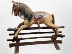 A reproduction carved wooden rocking horse on stand,