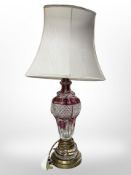 A two-tone cranberry glass brass-mounted table lamp with shade, overall height 65 cm.