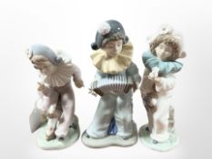 A Nao figure of a child playing acordion and two others.