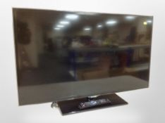 A Samsung 40 inch LCD TV with lead and remote on contemporary TV stand