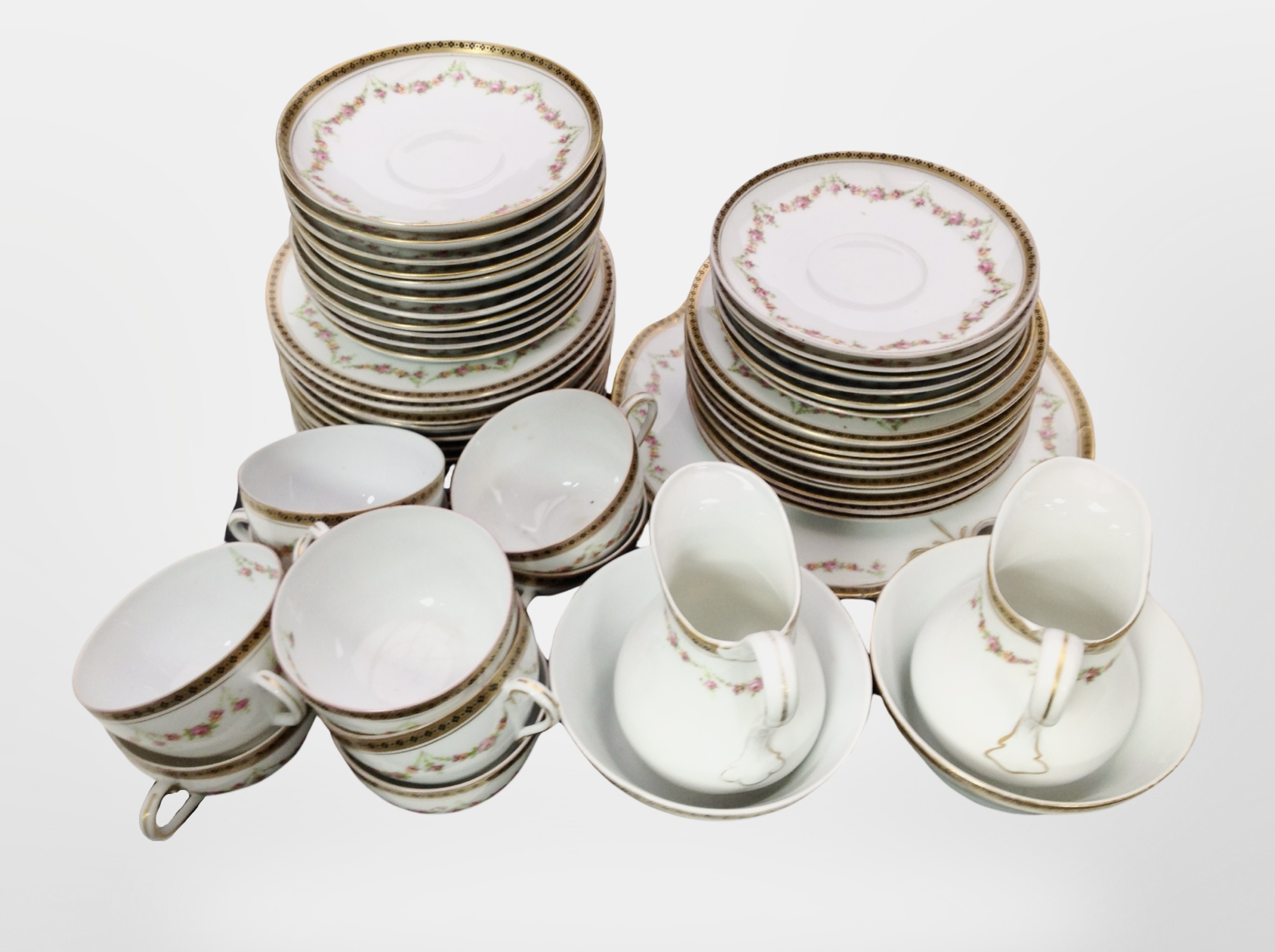 Approximately 52 pieces of early-20th century porcelain tea china hand painted with floral garlands.