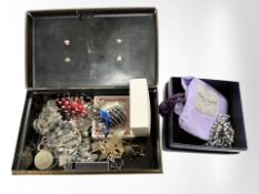 A tin of of costume jewellery, brooches, £1 coin, stone bracelet, amethyst pendant etc.