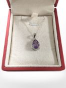 A faceted teardrop amethyst pendant on a silver chain.