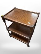 A stained teak three tier serving trolley,