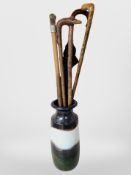 A West German pottery vase containing several walking sticks, including antler-handled example,