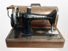 A Singer hand sewing machine in box