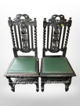 A pair of 19th century carved oak ebonised hall chairs