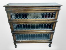 An Edwardian oak and leaded glass three tier stacking bookcase in the style of Globe-Wernicke,