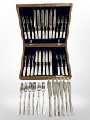 An oak canteen of EPNS and mother of pearl cake knives and forks with silver ferrules (lacking one