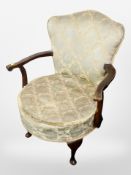 An early 20th century beech framed armchair in tasselled fabric