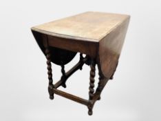 An Edwardian oak barley twist gate leg dining table,