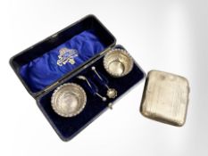 A cased pair of silver salts with spoons and a silver cigarette case.
