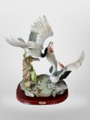 A large continental resin scultpure of two storks on plinth, height 42cm.