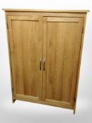 A contemporary oak cabinet with shelved interior,