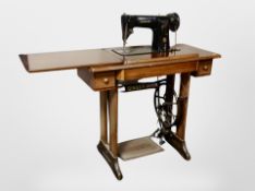 A Singer treadle sewing machine in walnut table