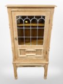 A Danish blonde oak leaded glass single door cabinet,