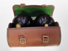 A pair of lawn bowls in leather carry case, marked Thomas Taylor, Glasgow No. 3.