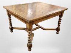 An Edwardian oak barley twist extending dining table,