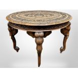 A Indian heavily carved hardwood oval occasional table, on elephant supports, 90 cm long,