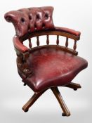 A Chesterfield oxblood buttoned leather swivel armchair