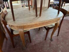 An early 20th century oak oval dining table on cabriole legs,