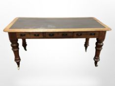 A late Victorian oak library table fitted three drawers with leather inset panel,