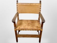 An early 20th-century Danish oak-framed armchair upholstered in studded tan leather, width 67cm.