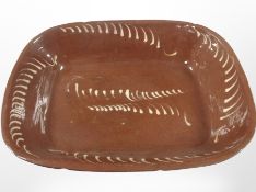 A 19th-century slipware oblong-shaped bowl, width 44cm.