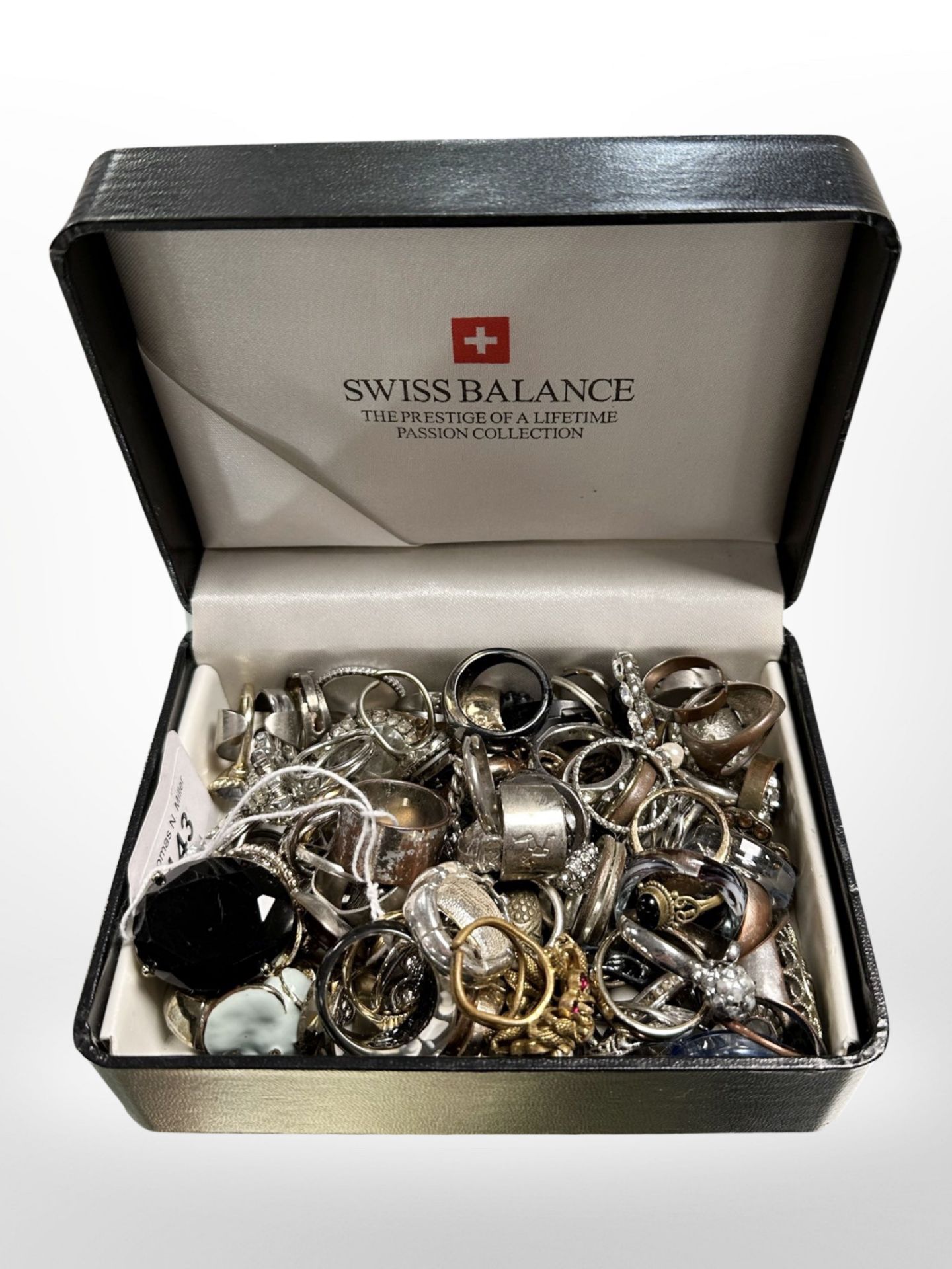 Swiss balance box containing over 100 costume rings, some silver.