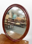 An early 20th-century mahogany oval mirror, 51cm x 41cm.