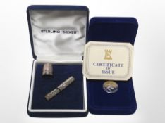 A silver thimble and needle case in box, and a further cased proof £1 coin with certificate.