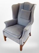 An early 20th-century wingback armchair in blue upholstery.