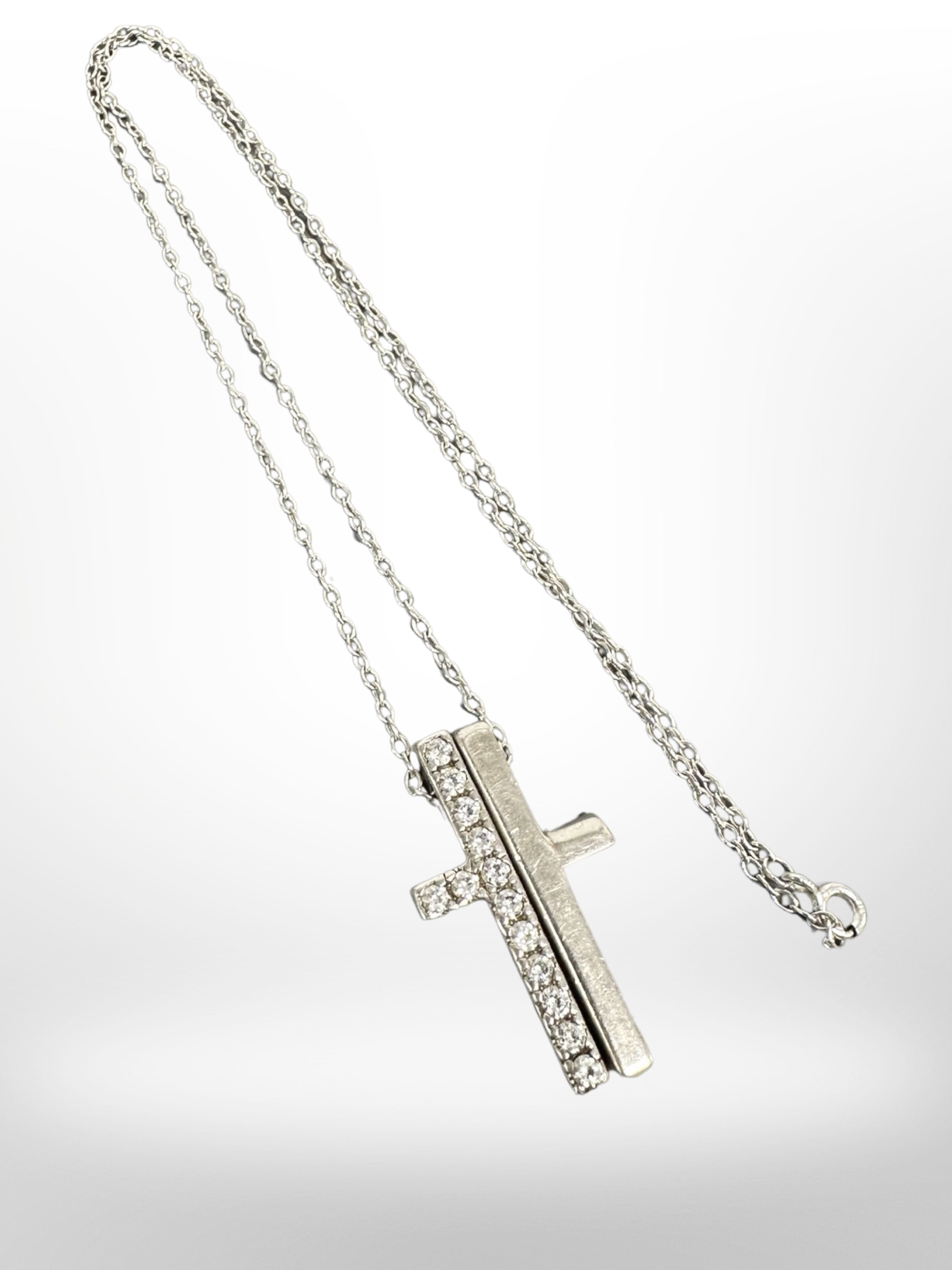 A split silver crucifix on chain, marked Gucci.