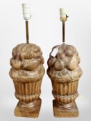 A pair of continental carved beech table lamp bases modelled as urns of fruit,