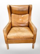 A mid 20th-century Danish wingback armchair upholstered in tan stitched leather, width 72cm.